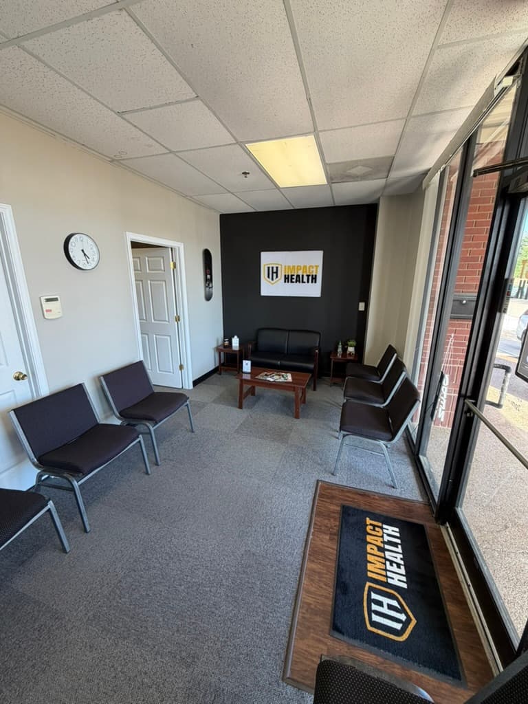 Impact Health Olive Branch lobby, branded floor mat, framed Impact Health sign, leather waiting chairs
