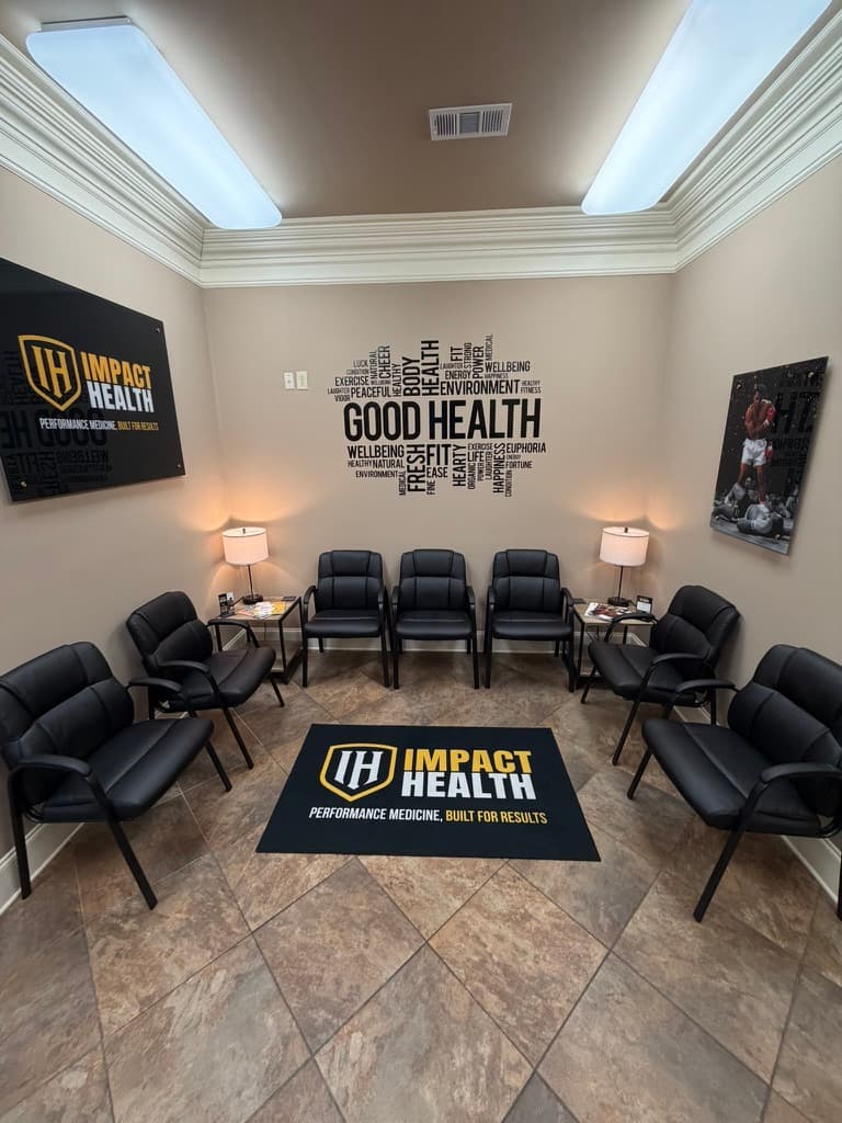 Oxford waiting room — wide angle showing Impact Health framed sign, GOOD HEALTH wellness mural, branded floor mat