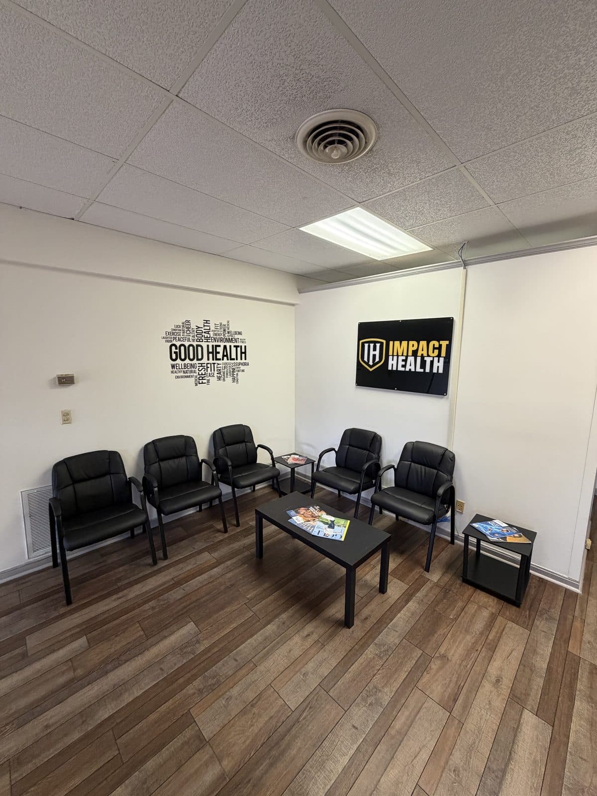 Waiting area at Impact Health Tupelo with the Good Health wall art and Impact Health sign